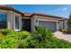 Close-up of a home's front exterior featuring a brick walkway, green landscaping, and a screened front entry at 1470 Hyssop Loop, North Port, FL 34289