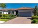 Charming home featuring a well-manicured front yard, brick driveway, and attached two-car garage at 1470 Hyssop Loop, North Port, FL 34289