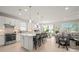 Bright open-concept kitchen featuring a spacious island, white cabinets, and stainless steel appliances at 1470 Hyssop Loop, North Port, FL 34289