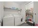 Laundry room with washer, dryer, sink and shelving featuring detergent and pantry items at 1470 Hyssop Loop, North Port, FL 34289