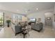 Comfortable living room with neutral tones, tile flooring, ceiling fan, and bright natural light at 1470 Hyssop Loop, North Port, FL 34289