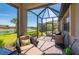Screened-in patio featuring comfortable furniture with a view of a lake at 1470 Hyssop Loop, North Port, FL 34289