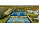 Aerial view of the community's tennis and pickleball courts with clubhouse in the background at 1470 Hyssop Loop, North Port, FL 34289