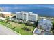 Aerial view of a modern condo complex surrounded by lush landscaping, set against a serene bay at 1500 Park Beach Cir # 5E, Punta Gorda, FL 33950