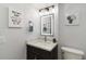 This half-bath features unique wall art, lighting, and a modern vanity and commode at 1500 Park Beach Cir # 5E, Punta Gorda, FL 33950