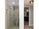 This bathroom has a tiled shower with glass doors, grab bar, and a view to the kitchen at 1500 Park Beach Cir # 5E, Punta Gorda, FL 33950