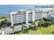 Exterior shot of a modern condo building with well-maintained landscaping and shaded parking at 1500 Park Beach Cir # 5E, Punta Gorda, FL 33950