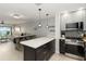 A combined kitchen and living space with stainless appliances, light fixtures, and countertops, offering both functionality and style at 1500 Park Beach Cir # 5E, Punta Gorda, FL 33950