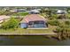 Aerial view of property showing screened-in pool, backyard, and canal access at 15698 Meacham Cir, Port Charlotte, FL 33981