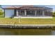 A rear view of the house and the screened-in pool as it faces the canal at 15698 Meacham Cir, Port Charlotte, FL 33981