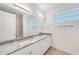 Bathroom featuring double granite vanity, large mirror, and a window at 15698 Meacham Cir, Port Charlotte, FL 33981