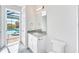 Bathroom featuring single granite vanity and view of screened-in pool at 15698 Meacham Cir, Port Charlotte, FL 33981