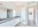 Bright bathroom featuring a granite countertop, double sinks, and a large mirror at 15698 Meacham Cir, Port Charlotte, FL 33981