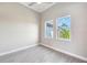 Bright bedroom with two windows offering views of the surrounding tropical landscape at 15698 Meacham Cir, Port Charlotte, FL 33981