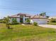 Beautiful home with tile roof, a manicured lawn, and a brick driveway at 15698 Meacham Cir, Port Charlotte, FL 33981