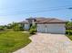 Elegant two-story home with well-manicured lawn and brick driveway at 15698 Meacham Cir, Port Charlotte, FL 33981