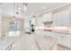 Close up of spacious kitchen island with white cabinets and granite countertops, complemented by modern stainless appliances at 15698 Meacham Cir, Port Charlotte, FL 33981