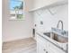 Bright laundry room features white cabinetry, granite countertop and tile flooring at 15698 Meacham Cir, Port Charlotte, FL 33981