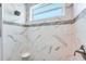 Walk-in shower featuring marble tile, mosaic accents and a window at 15698 Meacham Cir, Port Charlotte, FL 33981
