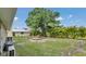 Spacious backyard with lush green grass, mature trees, and fire pit area, perfect for relaxing and entertaining at 1761 Okolona St, North Port, FL 34287