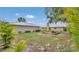 Spacious backyard with lush green grass, mature trees, and fire pit area, perfect for relaxing and entertaining at 1761 Okolona St, North Port, FL 34287