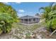 Large screened-in patio area with palm tree lined backyard at 1761 Okolona St, North Port, FL 34287