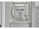 Bright bathroom featuring a white vanity, a large mirror and a shower behind a partial wall at 1761 Okolona St, North Port, FL 34287