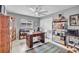 Bedroom with a large window, ceiling fan, and used as an office with wooden desk and bookshelves at 1761 Okolona St, North Port, FL 34287