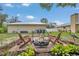 A paved fire pit area features Adirondack chairs, a fire pit, and minimal landscaping, providing an excellent backyard retreat at 1761 Okolona St, North Port, FL 34287