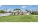Charming single-story home with a well-manicured lawn and manicured landscaping and a white fence at 1761 Okolona St, North Port, FL 34287