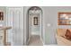 Bright hallway with neutral walls, tile flooring, and an arched doorway, offers seamless transitions at 1761 Okolona St, North Port, FL 34287