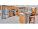 Bright kitchen showcasing stainless steel appliances, wood cabinets, and a center island with bar seating at 1761 Okolona St, North Port, FL 34287
