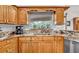 This kitchen has custom cabinets, granite counters, stainless appliances, and a window overlooking the pool at 1761 Okolona St, North Port, FL 34287