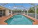 Relaxing screened-in pool featuring blue water and ample space for lounging and entertaining at 1761 Okolona St, North Port, FL 34287