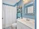 Charming bathroom with blue walls, vanity, and shower-tub combo offers a refreshing experience at 1876 Birmingham Blvd, Punta Gorda, FL 33980
