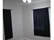 Bedroom with neutral walls, ceiling fan and windows covered with dark curtains at 21275 Austin Ave, Port Charlotte, FL 33952