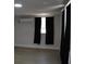 Bedroom featuring an air conditioning unit, wood floors, and a window with blinds and curtains at 21275 Austin Ave, Port Charlotte, FL 33952