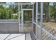 Enclosed porch area with decorative railings overlooking trees and yard at 21275 Austin Ave, Port Charlotte, FL 33952