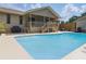 Backyard with a refreshing pool, patio space, and the home's covered back porch at 22349 Columbus Ave, Port Charlotte, FL 33954