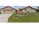View of home with a detached garage with a chain link fence and grass at 22349 Columbus Ave, Port Charlotte, FL 33954