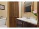 Cozy bathroom with wood-look vanity, white countertop, decorative mirror and wood-look doors at 22349 Columbus Ave, Port Charlotte, FL 33954