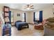 This charming bedroom features wood-look flooring, a ceiling fan and 3 windows with dark curtains at 22349 Columbus Ave, Port Charlotte, FL 33954