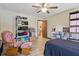 This bedroom features wood-look floors, a ceiling fan, and a comfortable rocking chair at 22349 Columbus Ave, Port Charlotte, FL 33954