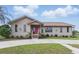 Charming single-story home with a manicured front yard and pink front door at 22349 Columbus Ave, Port Charlotte, FL 33954