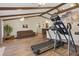 Living room featuring hardwood floors, exposed beam vaulted ceilings, and exercise equipment at 22349 Columbus Ave, Port Charlotte, FL 33954