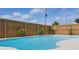 Sparkling in-ground swimming pool with a concrete deck, fenced yard, and lush landscaping at 22349 Columbus Ave, Port Charlotte, FL 33954