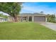 Charming home featuring a well-manicured lawn, mature trees, and a two-car garage at 22353 Blanchard Ave, Port Charlotte, FL 33952