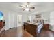 Bedroom with wood floors, ensuite bathroom, striped bedding, and a ceiling fan at 22353 Blanchard Ave, Port Charlotte, FL 33952