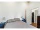 Bright bedroom featuring two bedside tables, a bed, and a doorway leading to an ensuite bathroom at 233 N New York Ave, Englewood, FL 34223