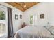 Bright bedroom features a wood-paneled ceiling, white walls, and a door leading to a deck at 233 N New York Ave, Englewood, FL 34223